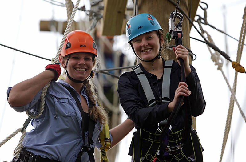 Two girls on the adventure park smile at the camera