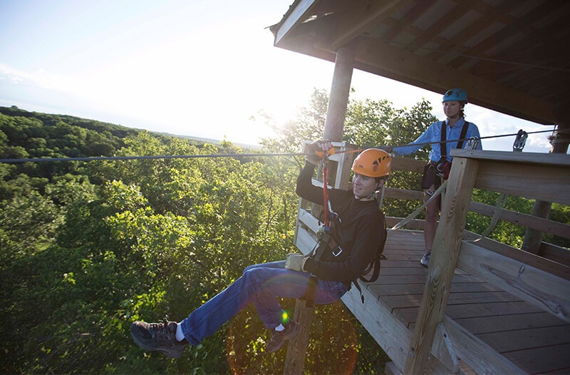 Zipliner jumps off platform and begins to fly through the air