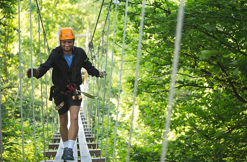 Man looks down while running across the kerfoot suspension bridge