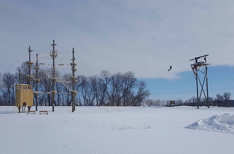 Man flies through the air on the Winter ziplining course